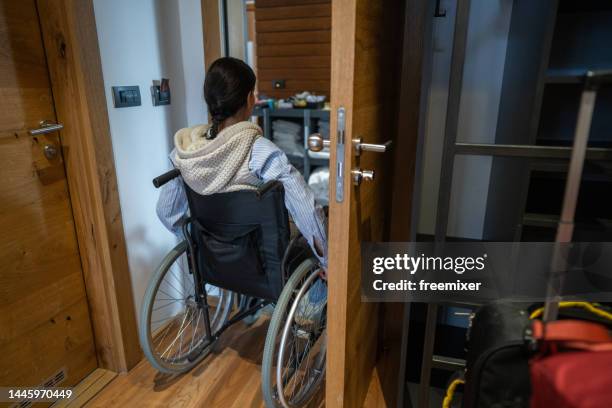 behinderte frau im rollstuhl verlässt das hotelzimmer - hotelzimmer tür stock-fotos und bilder