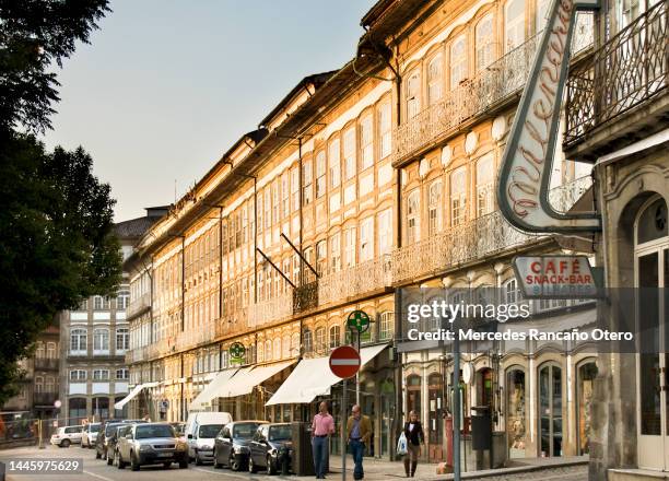 largo do toural residential buildings, traditional facades, pedestrians, traffic, city life in guimarães, portugal. - braga district 個照片及圖片檔