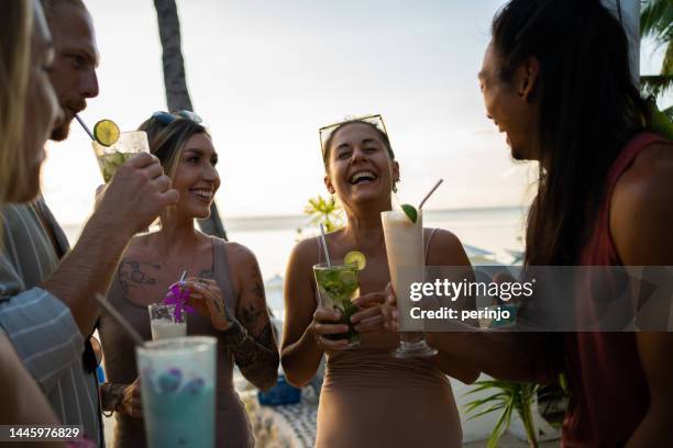 multiracial friends having fun during cocktails time at the beach bar - mojito stock pictures, royalty-free photos & images