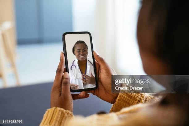 unrecognisable african woman using digital device during illness, talking to doctor on video call - telemedicine stock pictures, royalty-free photos & images