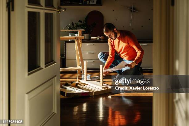 young adult man assembling new trestle furniture in the morning at home - decoração de quarto rapaz imagens e fotografias de stock