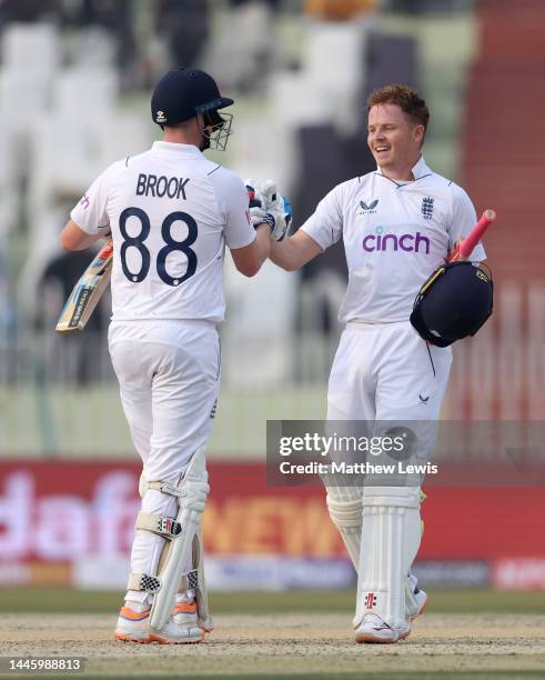 Ollie Pope of England celebrates reaching his century with Harry Brookduring the First Test Match between Pakistan and England at Rawalpindi Cricket...