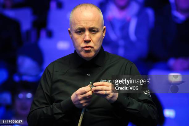 John Higgins of Scotland chalks the cue during the first round match against Cao Yupeng of China on day three of the 2022 BetVictor Scottish Open at...