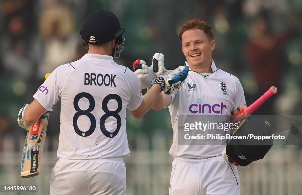Ollie Pope of England celebrates reaching his century with Harry Brook during the first day of the first Test between Pakistan and England at...