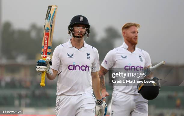 Harry Brook of England salutes the crowd alongside captain Ben Stokes as he leaves the field at stumps on the First Test Match between Pakistan and...