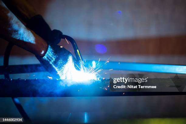 close-up shot of an industrial welder use carbon arc welding torches for spot welding of a metal grate in a metal workshop. - metalwork stock-fotos und bilder