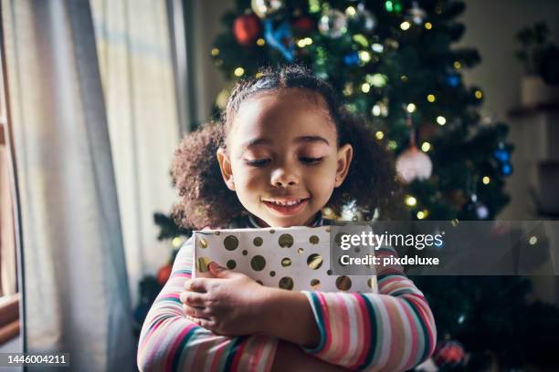 weihnachten, urlaub und junges mädchen mit geschenk, glücklich und danke für geschenk, feier bei familie zu hause. kinderumarmung geschenkbox, feiern im haus wohnzimmer und festliche stimmung, lächeln und glück. - thank you smile stock-fotos und bilder