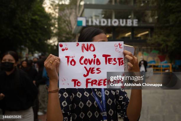 Tibetan youth holds a placard during a protest against China's zero-covid policy on December 01, 2022 in Bengaluru, India. Protesters took to the...