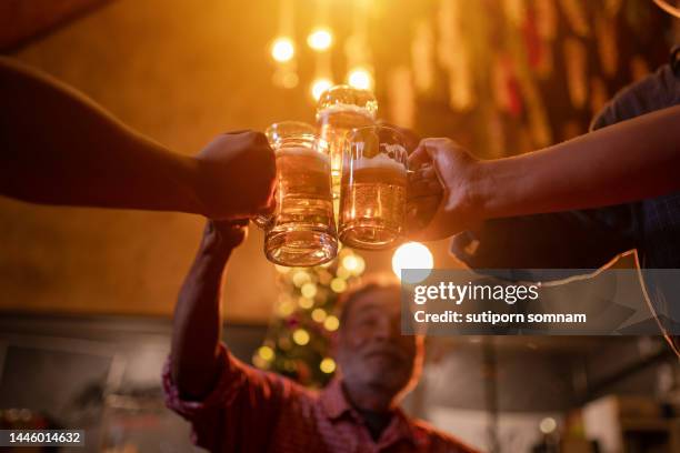 close-up senior of hands toasting beer, at a pub party - beer nuts stock-fotos und bilder
