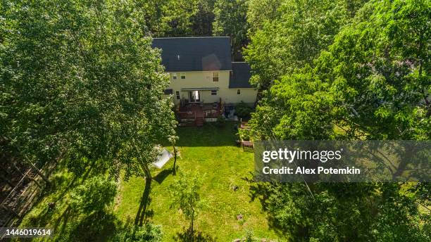 freistehendes einfamilienhaus in einer wohnanlage in poconos, pennsylvania, an einem sonnigen sommertag. sonne erzeugt starke linsenreflexion. - markise garten stock-fotos und bilder