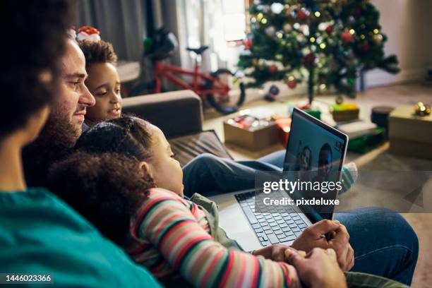 christmas, laptop and video call with a family together on a sofa in their home living room for communication. computer, online chat and grandparents with a girl and parents in the festive season - chat noel stockfoto's en -beelden