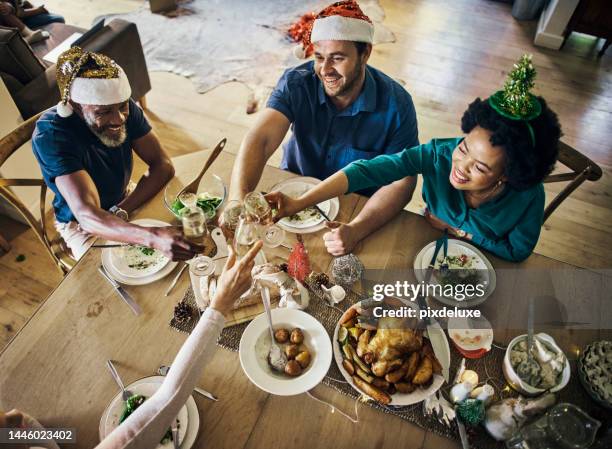 christmas, family and toast from above with wine for festive season lunch party together. xmas, food and dinner table with people cheers with wine for december tradition - friends toasting above table stock pictures, royalty-free photos & images