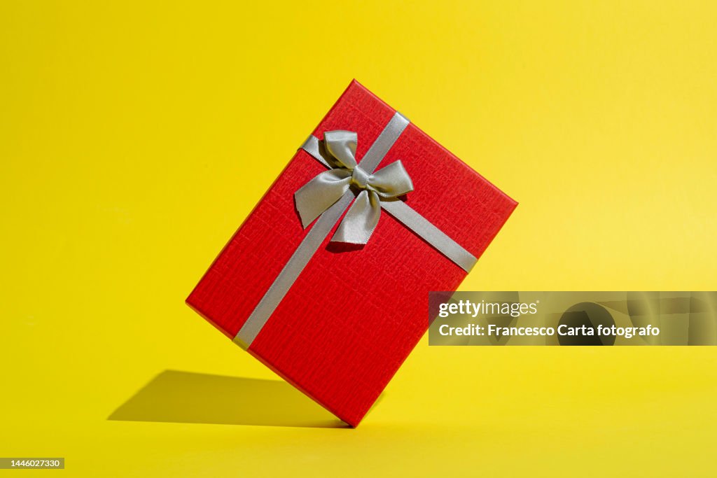 Red gift box with silver ribbon tied