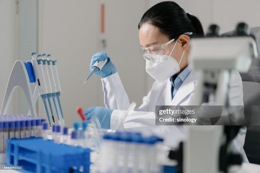Scientist adding reagents to centrifuge tubes in laboratory