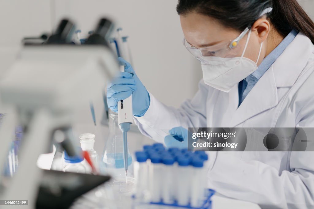 Scientist is adding reagents to microscope slide in laboratory