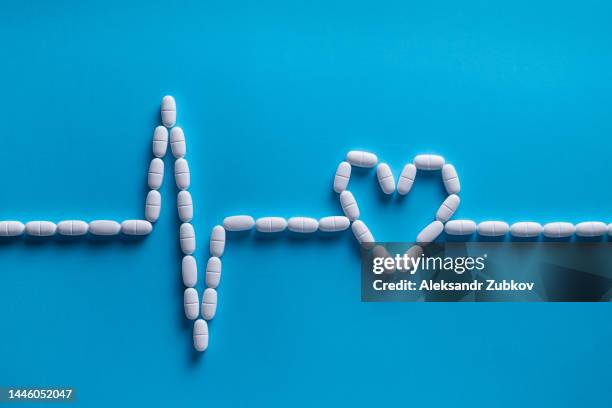 capsules and tablets in the form of a cardiogram. vitamins, painkillers, medications. heart-shaped pills. the concept of pharmaceuticals, prevention and treatment of heart diseases, healthcare and medicine. ischemia, stroke and myocardial infarction. - heart pill stock-fotos und bilder