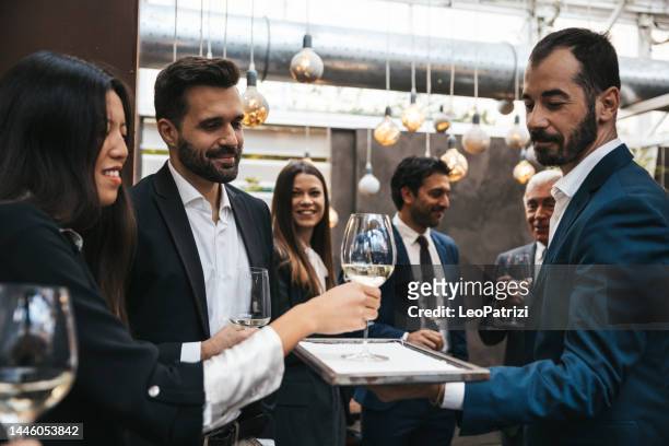 waiter serves champagne at a business meeting - chinese waiter stock pictures, royalty-free photos & images