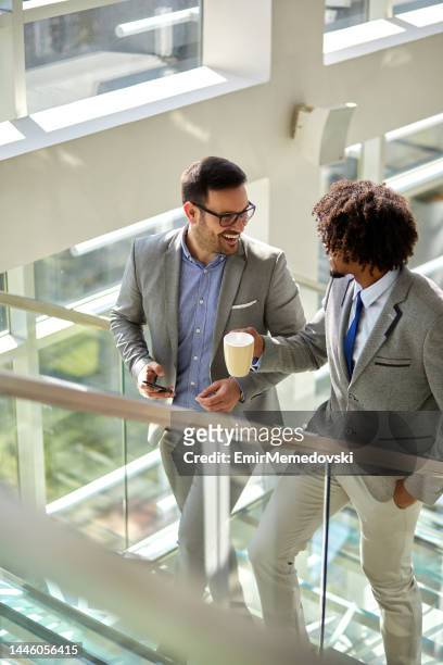 two business colleagues talking while ascending stairs - stairs business stock pictures, royalty-free photos & images