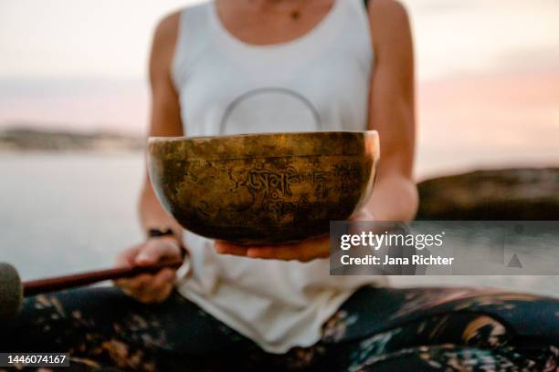slim woman holds singing bowl in her hands - closeup - gong stock pictures, royalty-free photos & images