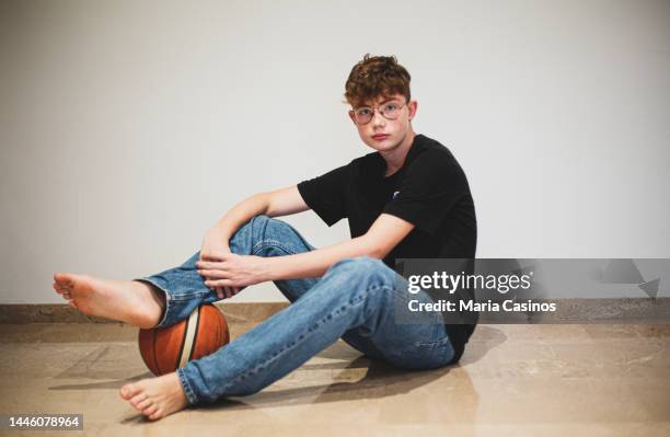 バスケットボールボールを持つ10代の少年のポートレート - barefoot redhead ストックフォトと画像