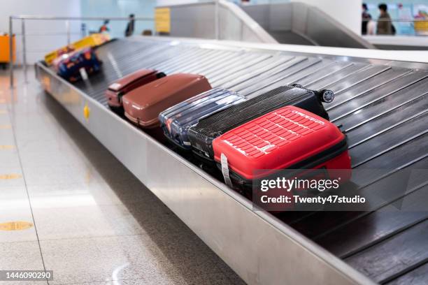 luggages on conveyor belt in the airport - hand luggage stock pictures, royalty-free photos & images