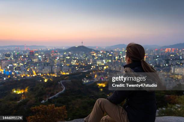 rear view of woman enjoying the view of seoul city at inwangsan mountain in the morning - south korea people stock pictures, royalty-free photos & images