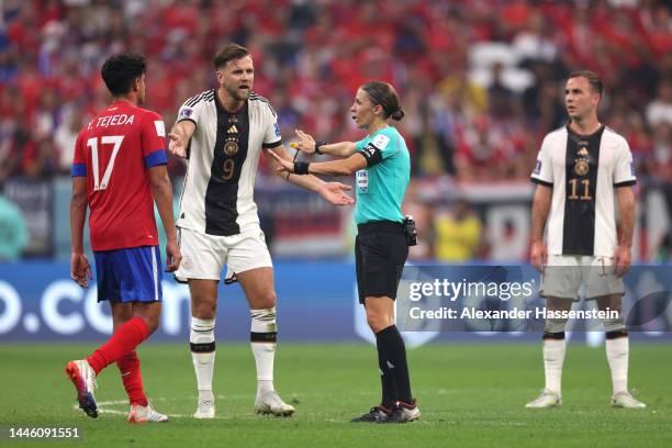 Referee Stephanie Frappart looks on with Niclas Fuellkrug of Germany before awarding Germany their fourth goal after a VAR check during the FIFA...