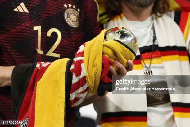 Germany fan holds a replica FIFA World Cup trophy after their sides' elimination from the tournament during the FIFA World Cup Qatar 2022 Group E...
