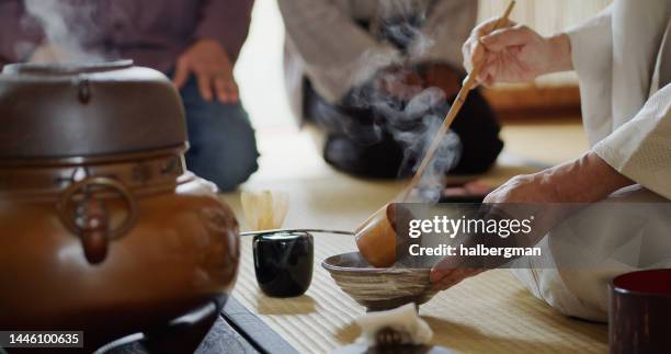 tea ceremony host preparing tea while guests eat - tea ceremony stock pictures, royalty-free photos & images