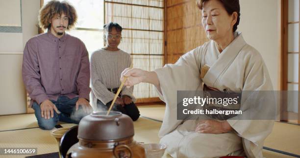 guests watching hostess preparing tea at traditional japanese ceremony - japan tourism stock pictures, royalty-free photos & images