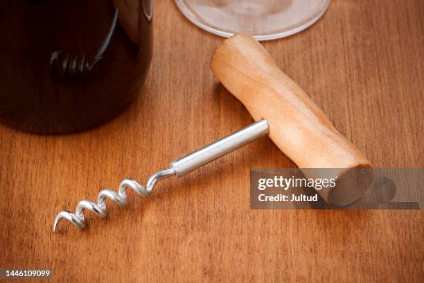 macro shot of a corkscrew on a wooden board - corkscrew foto e immagini stock