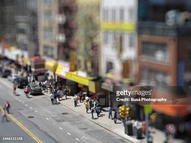 view from above of busy sidewalk in chinatown, manhattan, new york city (blurred image) - tilt shift stock pictures, royalty-free photos & images
