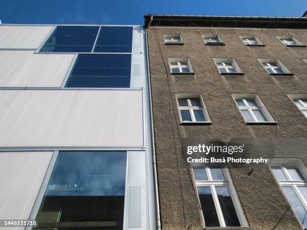 contrast between old pre-war residential building and modern condominium housing building in the district of mitte, in berlin, germany - gentrification of east berlin continues stock pictures, royalty-free photos & images