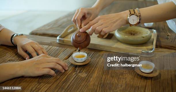 handheld shot of woman pouring tea for friends - taipei tea stock pictures, royalty-free photos & images