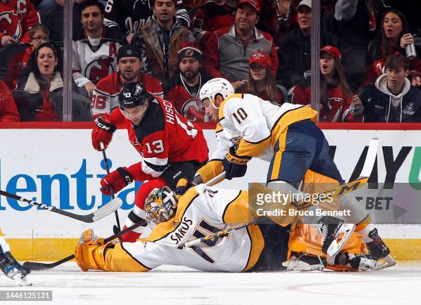 Juuse Saros of the Nashville Predators leaves the net to defend against Nico Hischier of the New Jersey Devils during the first period at the...
