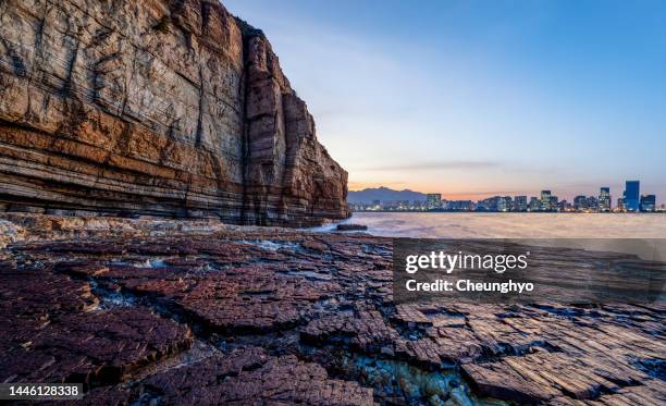 auto advertising backplate. low angle view of shale landform in front of city skyline at dawn - shale stock pictures, royalty-free photos & images