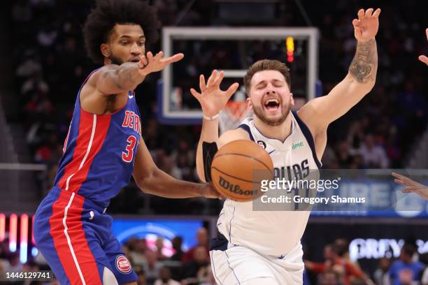 Luka Doncic of the Dallas Mavericks battles for the ball against Marvin Bagley III of the Detroit Pistons during the first period at Little Caesars...