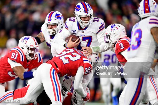 Quarterback Josh Allen of the Buffalo Bills is tackled by safety Devin McCourty of the New England Patriots in the first half at Gillette Stadium on...
