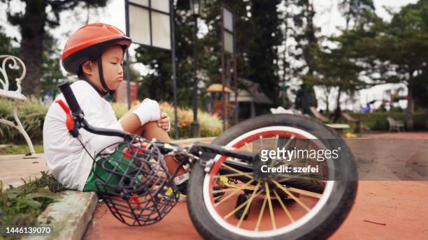 asian boy falling off from bicycle. - falling off bike stock-fotos und bilder