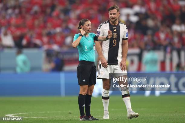 Referee Stephanie Frappart looks on with Niclas Füllkrug of Germany before awarding Germany their fourth goal after a VAR check during the FIFA World...