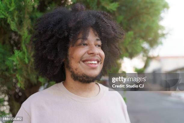 portrait of young man with afro hair looking to the side outdoors during sunset - big hair stock pictures, royalty-free photos & images