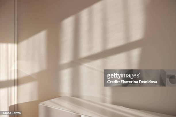 white walls with sunlight from window - licht stock-fotos und bilder