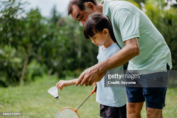 grandfather and granddaughter playing badminton - badminton sport stockfoto's en -beelden