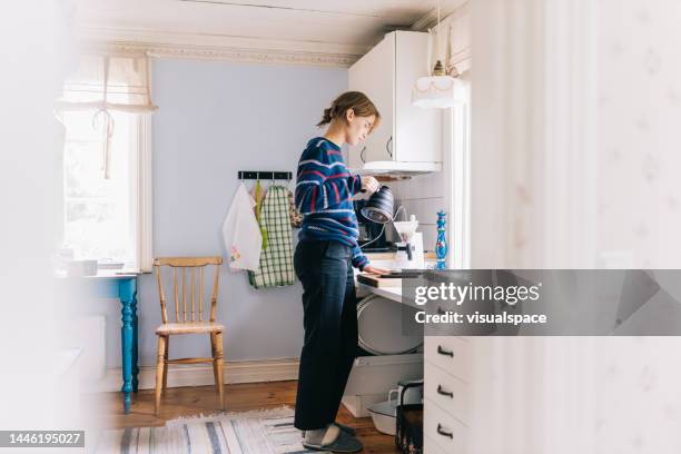 young woman making morning coffee - scandinavian descent 個照片及圖片檔