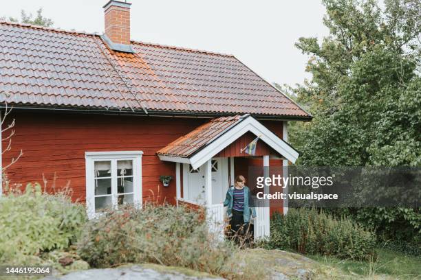 young woman spending time at her summer cottage - cabin stockfoto's en -beelden