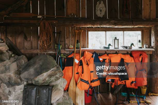 chalecos salvavidas en la casa del lago - boathouse fotografías e imágenes de stock