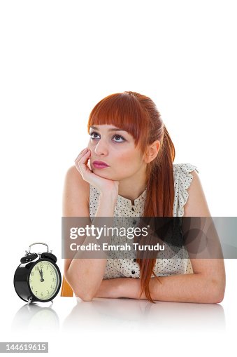 Young woman sitting with alarm clock Young woman sitting with alarm clock