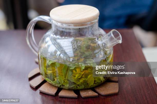 herbal tea in a transparent teapot, close-up - tisana foto e immagini stock