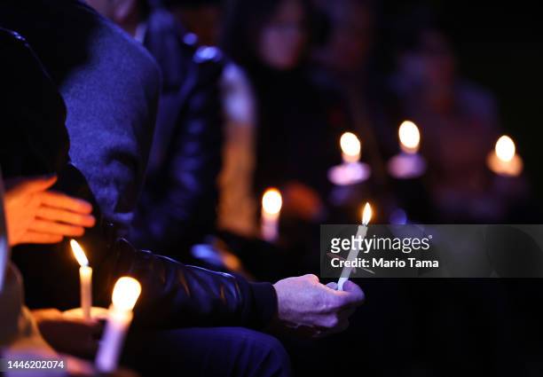 People hold candles during a World AIDS Day commemoration event at The Wall Las Memorias AIDS Monument on December 1, 2022 in Los Angeles,...