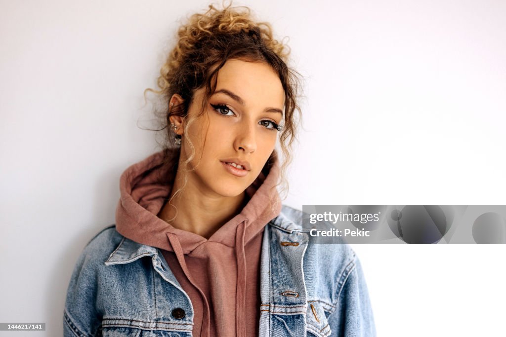 Portrait of a young adult woman against a white background